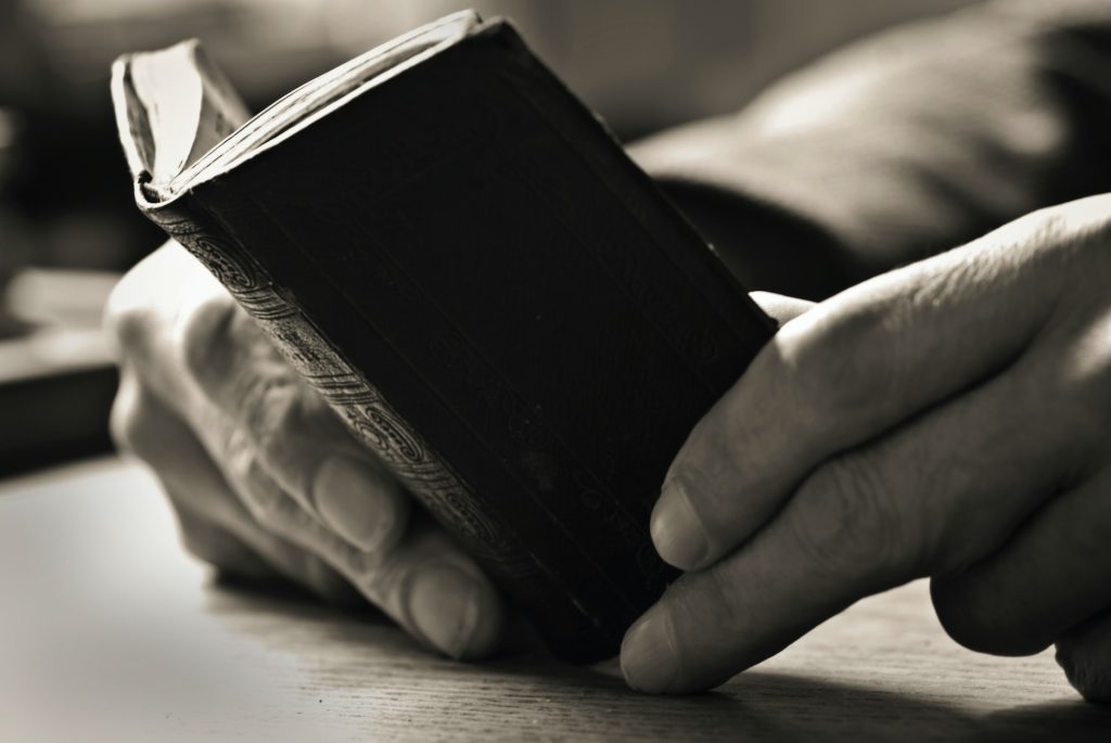 Man holds very small book to show that a shorter book is a better book. This requires a professional book editor, such as Cleveland, Tennessee's Daniel K. Brantley.