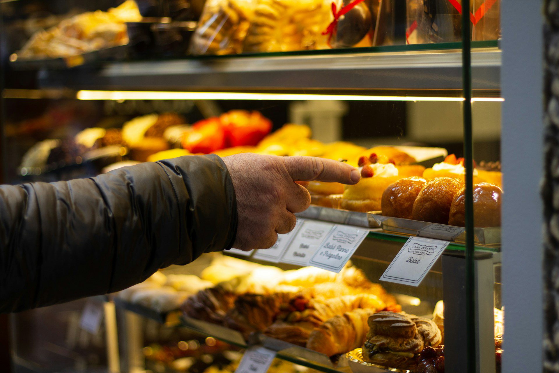 Image shows hand pointing at pastries,  illustrating the idea of looking for a good resume writer.